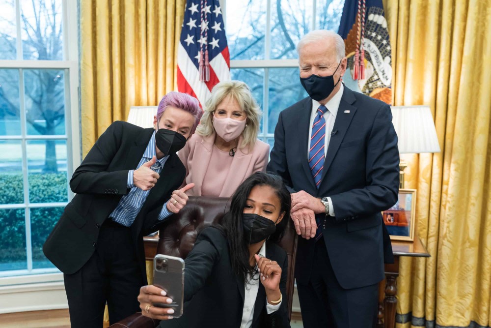 El presidente Joe Biden y la primera dama Jill Biden posan para una selfie con jugadoras del equipo de fútbol femenino nacional de los EE UU., Megan Rapinoe y Margaret “Midge” Purce el miércoles 24 de marzo de 2021, en la Oficina Oval de la Casa Blanca.