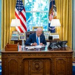 President Biden seated at the Resolute Desk in The Oval Office
