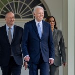 President Joe Biden walks with Vice President Kamala Harris and Second Gentleman Doug Emhoff along the Colonnade of the White House