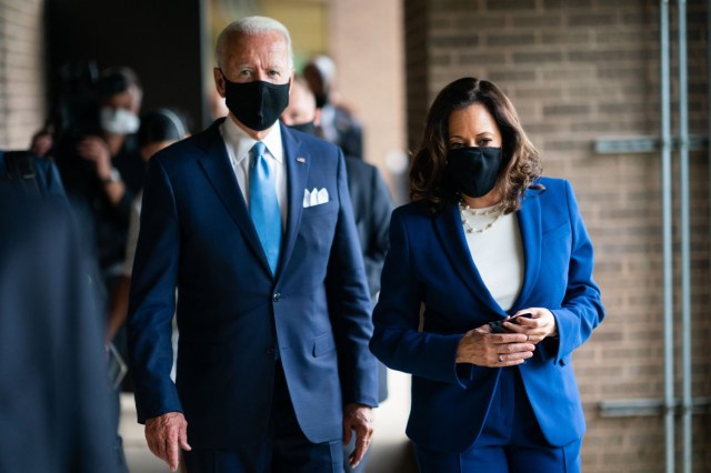 President Biden and Vice President Harris walking while wearing masks.