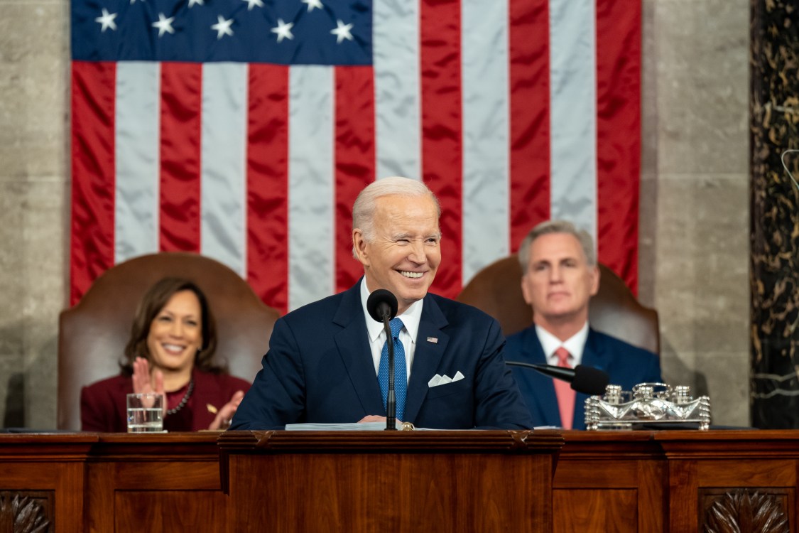 President Joe Biden delivering the 2023 State of the Union with Vice President Harris and Speaker McCarthy sitting behind him.