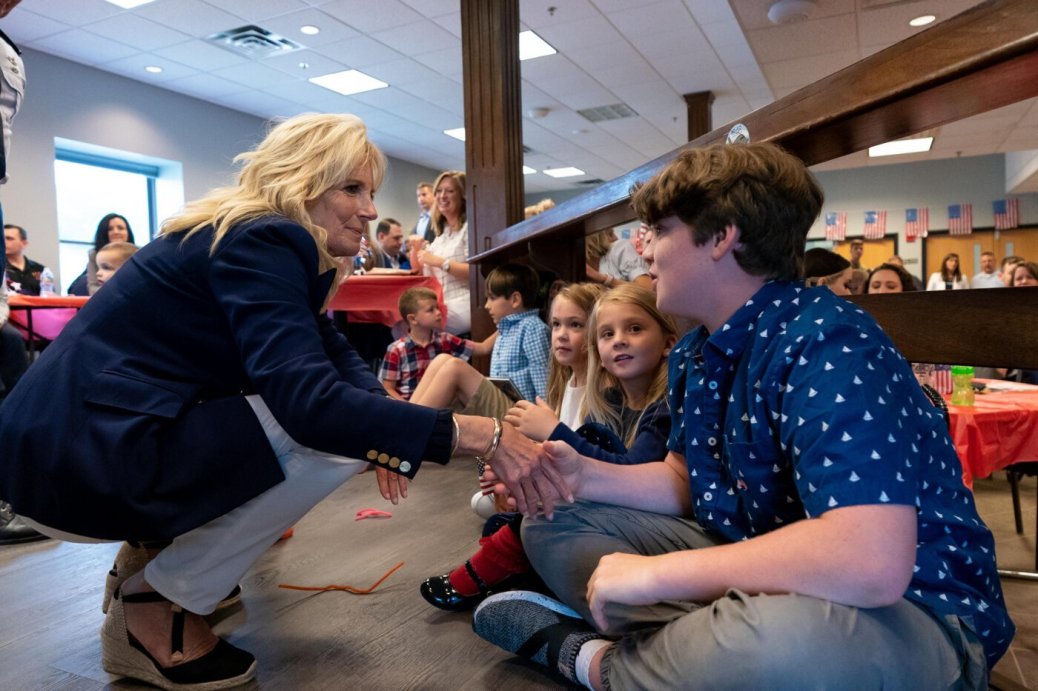 First Lady Jill Biden shakes the hand of a young military child
