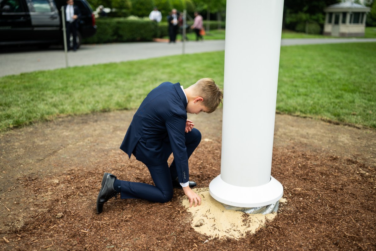 President Donald Trump’s grandson picks up sand at the base of the newly-installed flagpole on the South Lawn of the White House, Wednesday, June 18, 2025. (Official White House Photo by Daniel Torok)