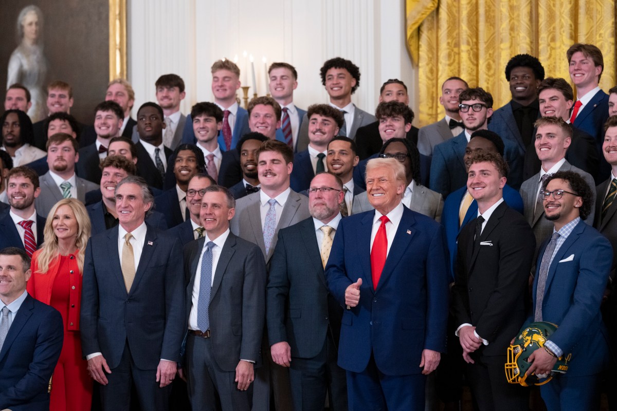 North Dakota State University Bison football coach Tim Polasek and quarterback Cam Miller present a commemorative jersey and helmet to President Donald Trump, Wednesday, April 9, 2025, in the East Room of the White House. (Official White House Photo by Molly Riley)