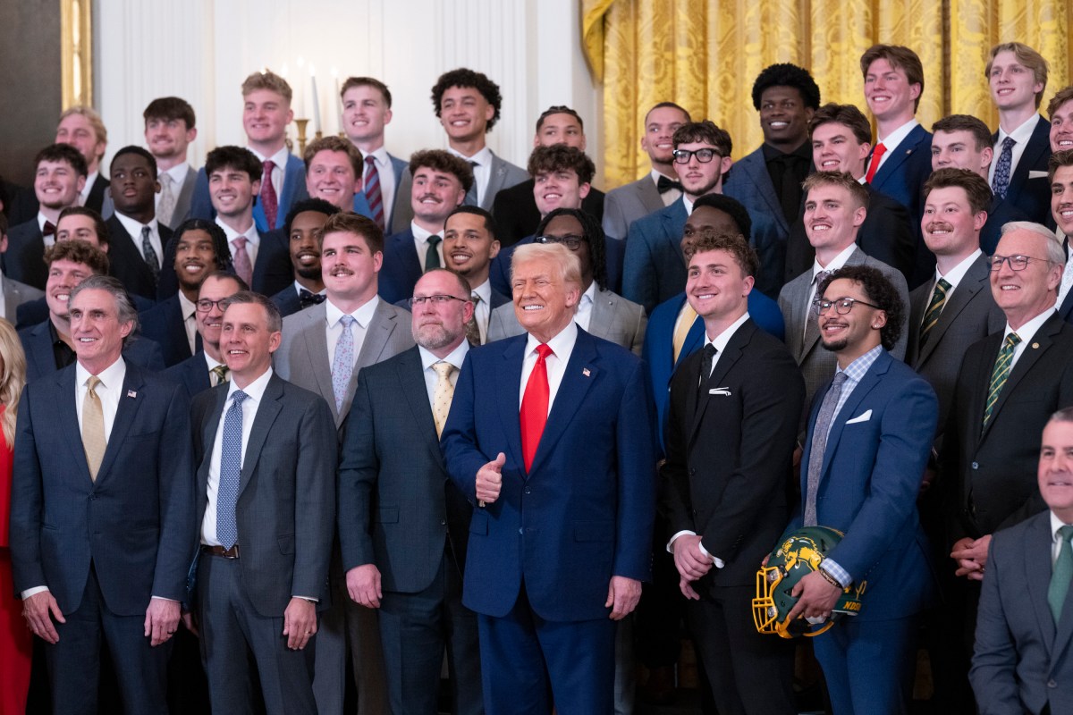 North Dakota State University Bison football coach Tim Polasek and quarterback Cam Miller present a commemorative jersey and helmet to President Donald Trump, Wednesday, April 9, 2025, in the East Room of the White House. (Official White House Photo by Molly Riley)