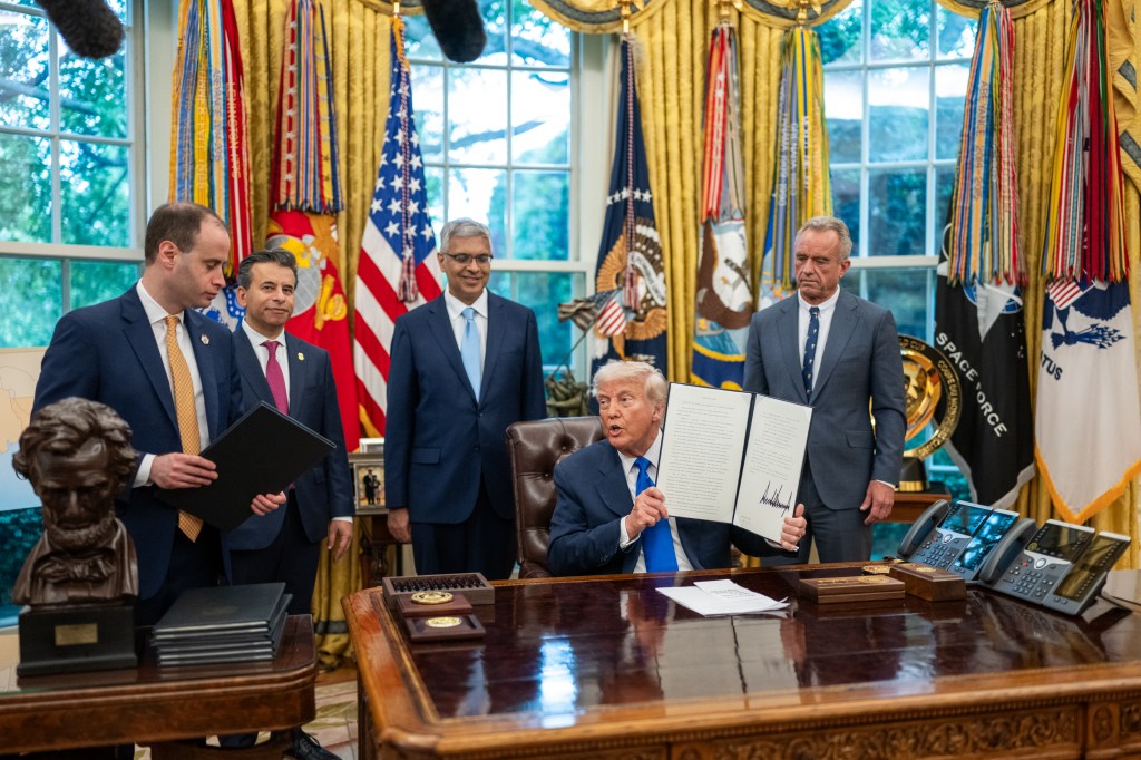 President Donald Trump signs executive orders flanked by Secretary of Health and Human Services Robert F. Kennedy, Jr. and Director of the National Institutes of Health Jay Bhattacharya, Monday, May 5, 2025, in the Oval Office. (Official White House Photo by Molly Riley)
