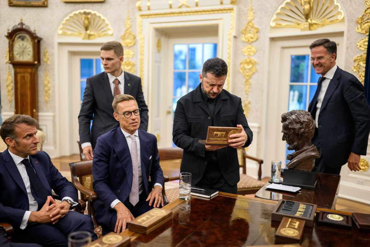 Ukrainian President Volodymyr Zelenskyy holds a gift from President Donald Trump after a meeting with European leaders, Monday, August 18, 2025, in the Oval Office. (Official White House Photo by Daniel Torok)