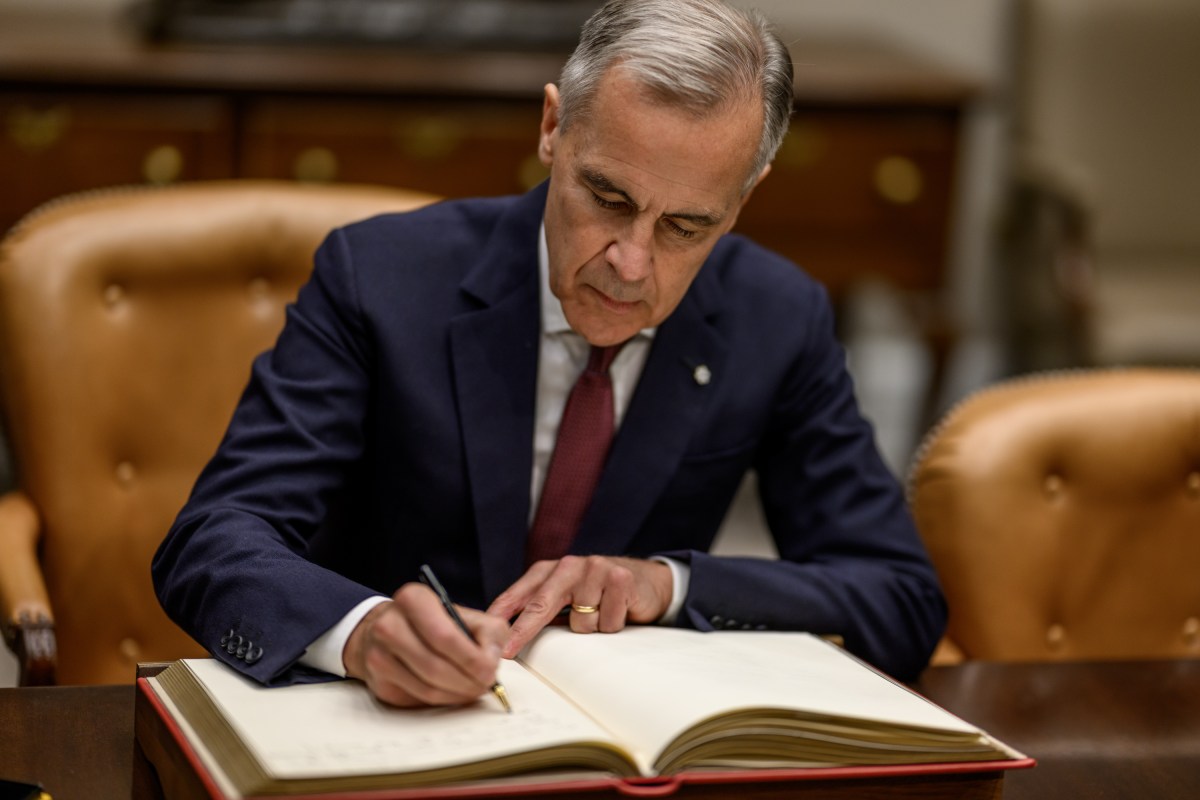 President Donald Trump looks on as Canadian Prime Minister Mark Carney signs the guest book in the Roosevelt Room before a meeting with President Donald Trump, Tuesday, October 7, 2025. (Official White House Photo by Daniel Torok)