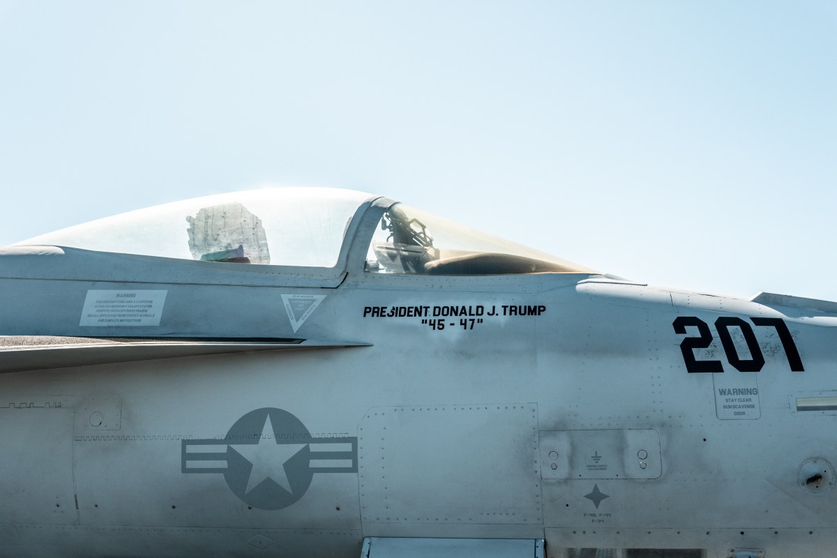 A military jet adorned with U.S. President Donald Trump's name is seen aboard the USS George H.W. Bush aircraft carrier after observing naval flight demonstrations on October 5, 2025 off the eastern coast of the United States. President Trump is visiting Naval Station Norfolk in Virginia for a celebration of the 250th birthday of the U.S. Navy. (Official White House Photo by Andrea Hanks)