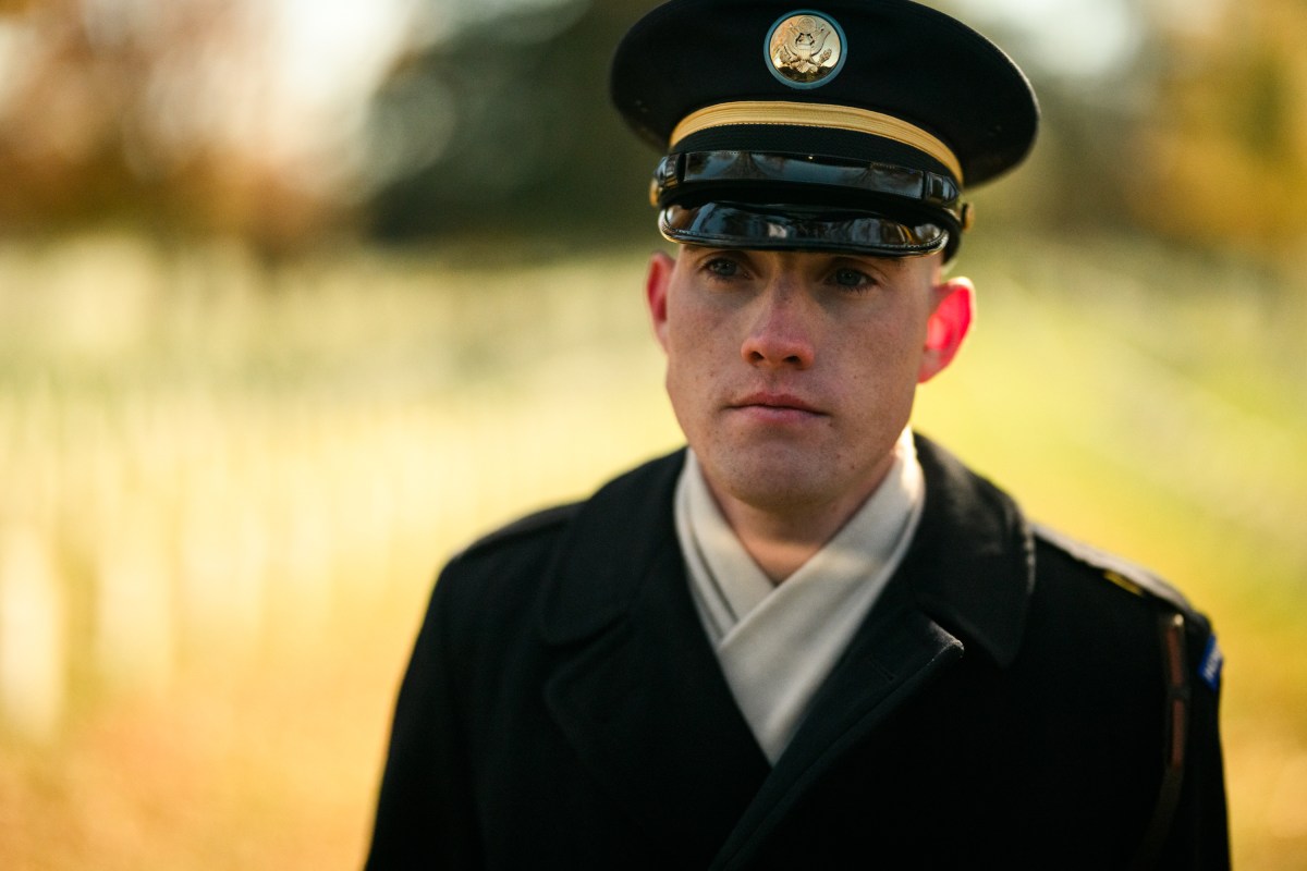 A member of the military stands at attention as President Donald Trump’s motorcade departs Arlington National Cemetery, after a Veterans Day ceremony, Tuesday, November 11, 2025, in Arlington, Virginia. (Official White House Photo by Daniel Torok)