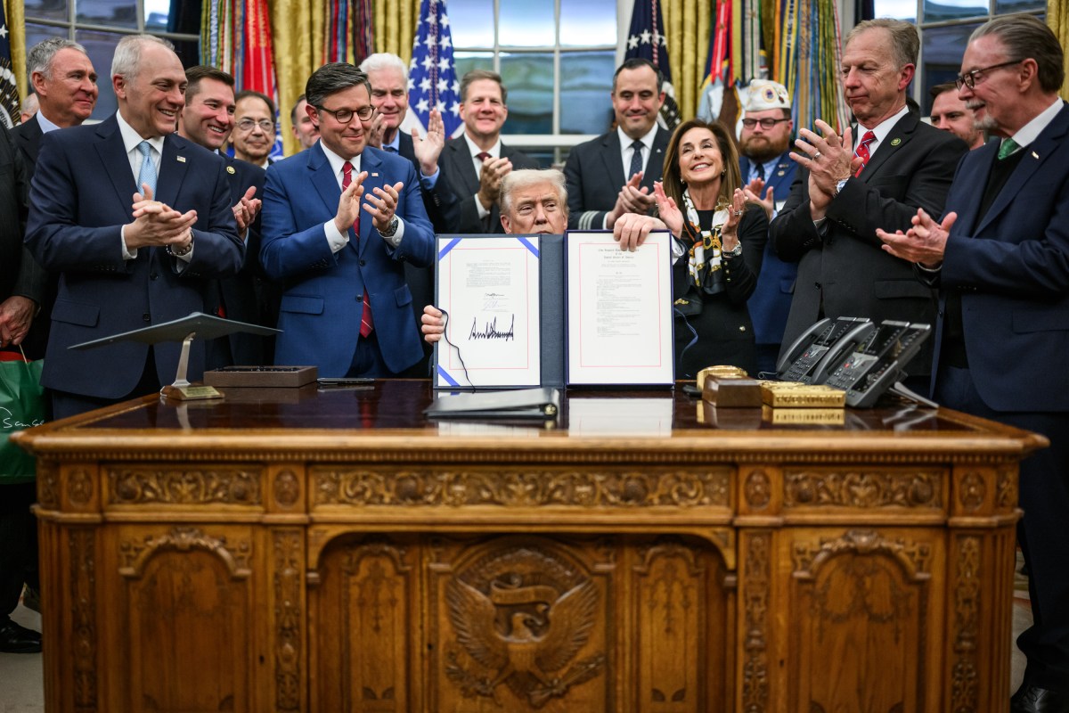 President Donald Trump shows members of the media the signed bill from Congress that reopens the government, Wednesday, November 12, 2025, in the Oval Office. (Official White House Photo by Daniel Torok)
