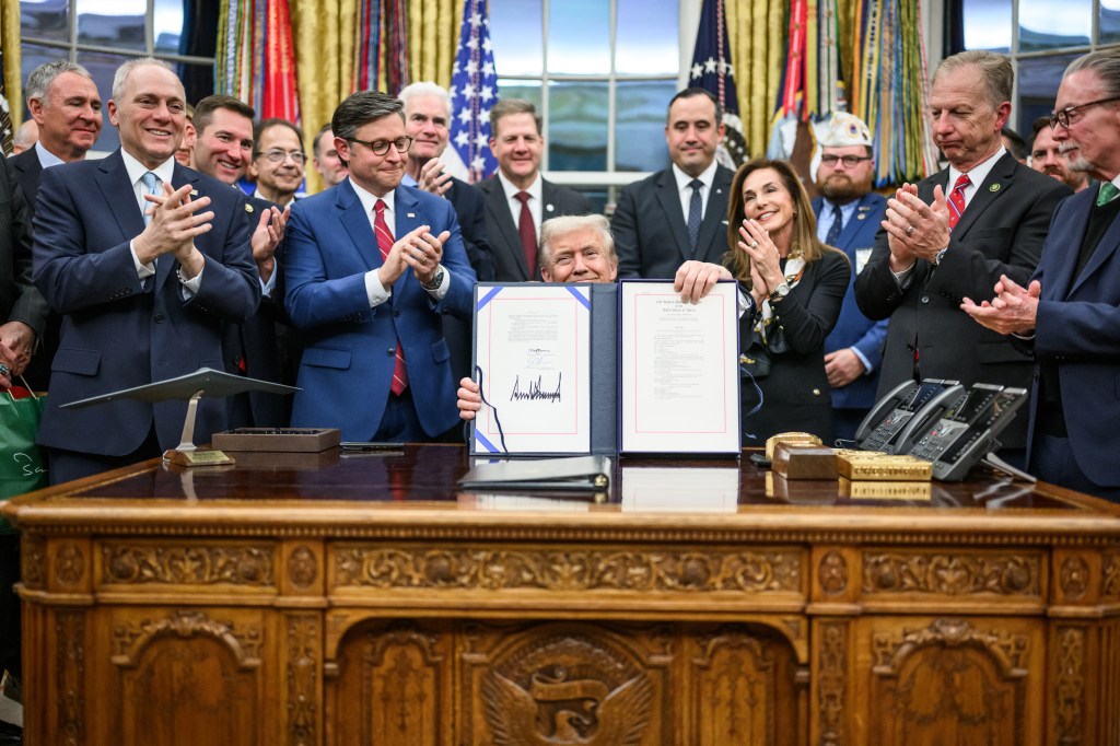 President Donald Trump shows members of the media the signed bill from Congress that reopens the government, Wednesday, November 12, 2025, in the Oval Office. (Official White House Photo by Daniel Torok)
